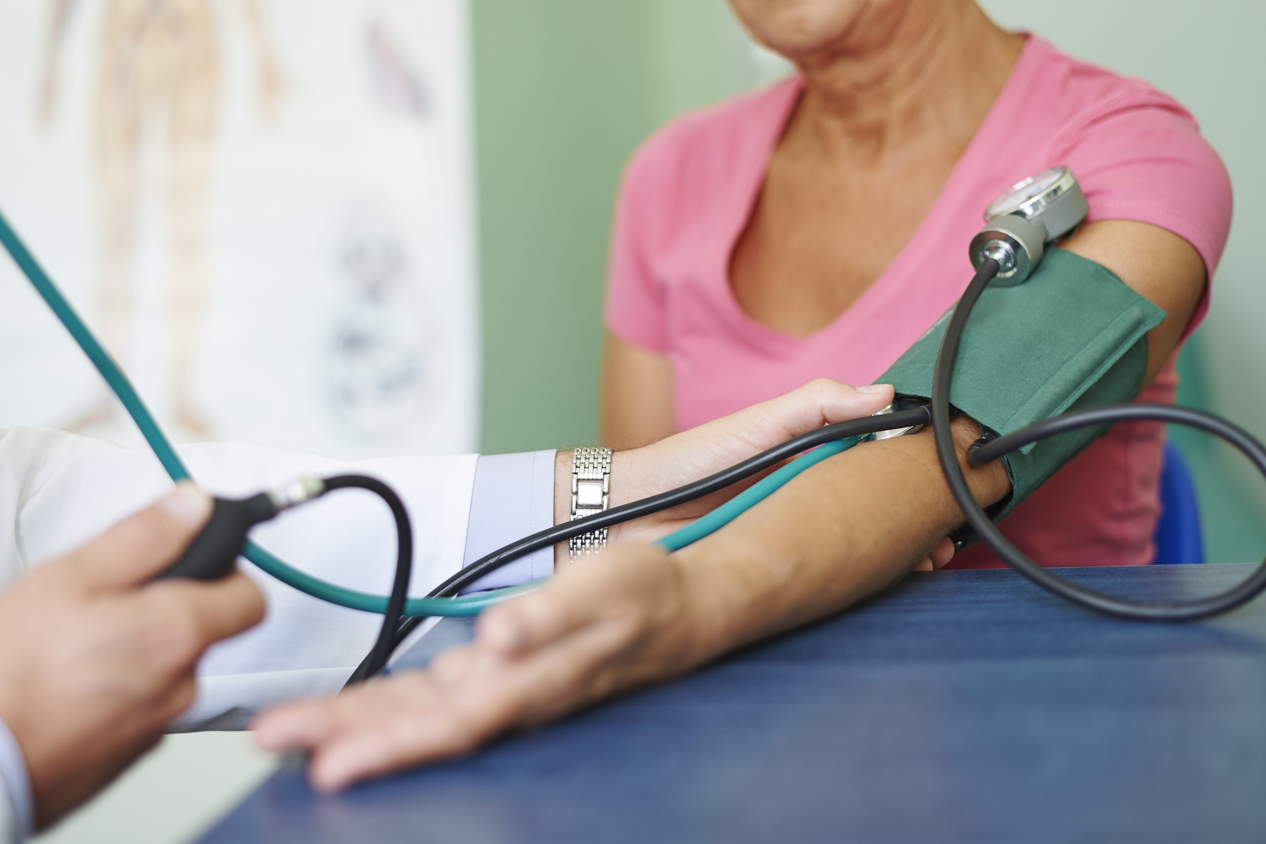 Doctor measures pressure in senior patient